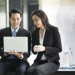 Asian business people working together on a laptop
